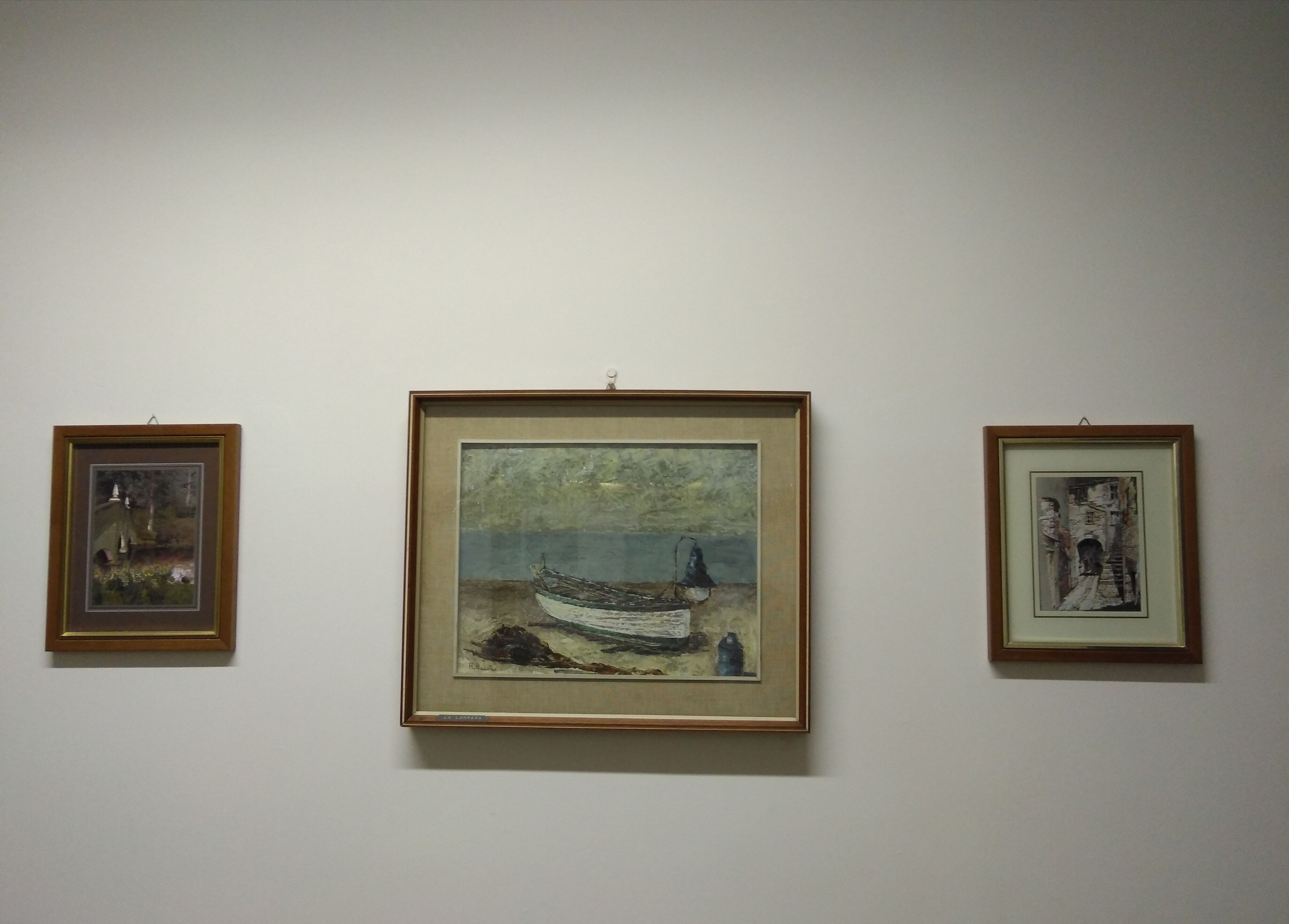 Three framed artworks on a wall.