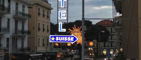 A hotel sign with a neon sign indicating direction to Switzerland.