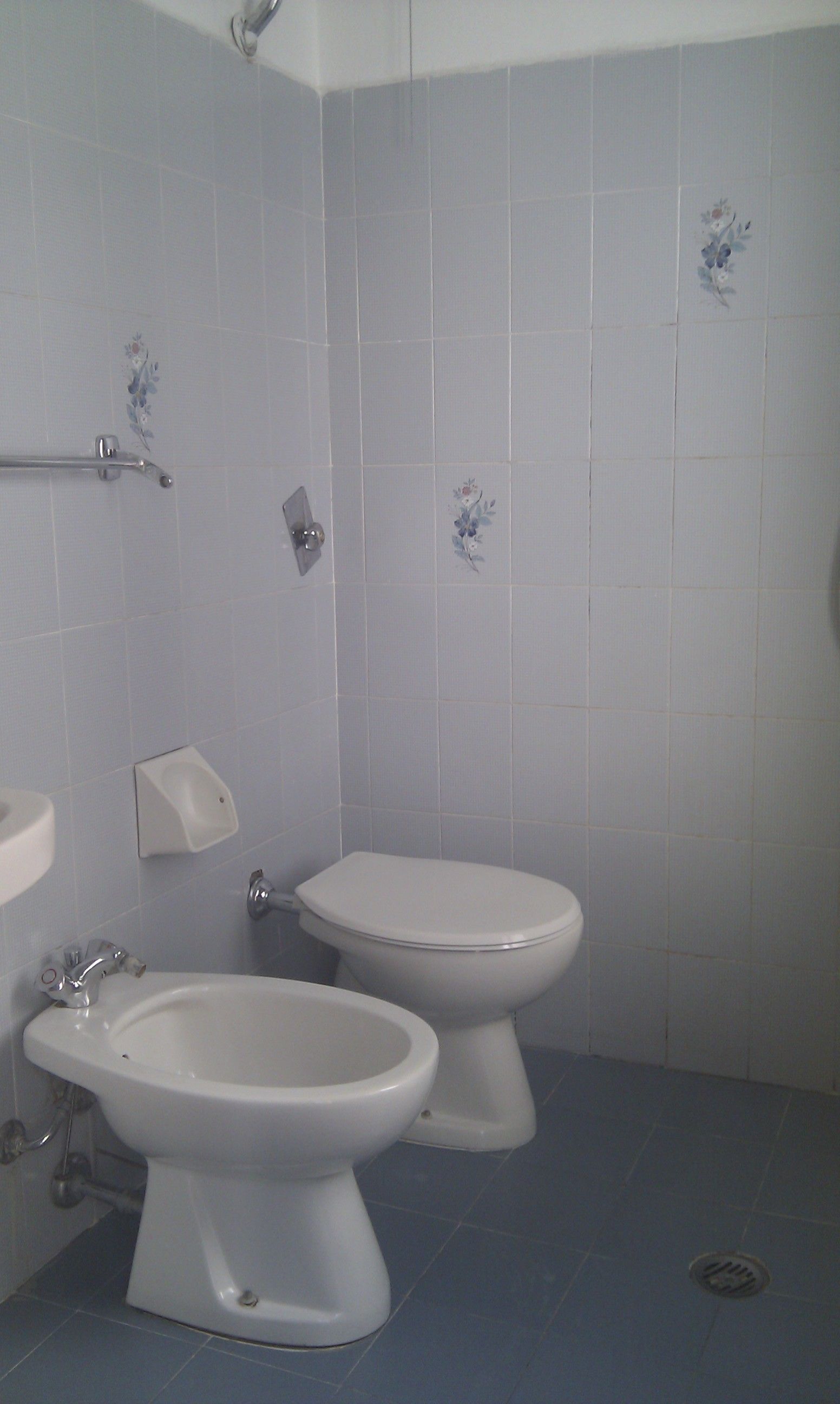 A bathroom with a toilet, bidet, and sink.