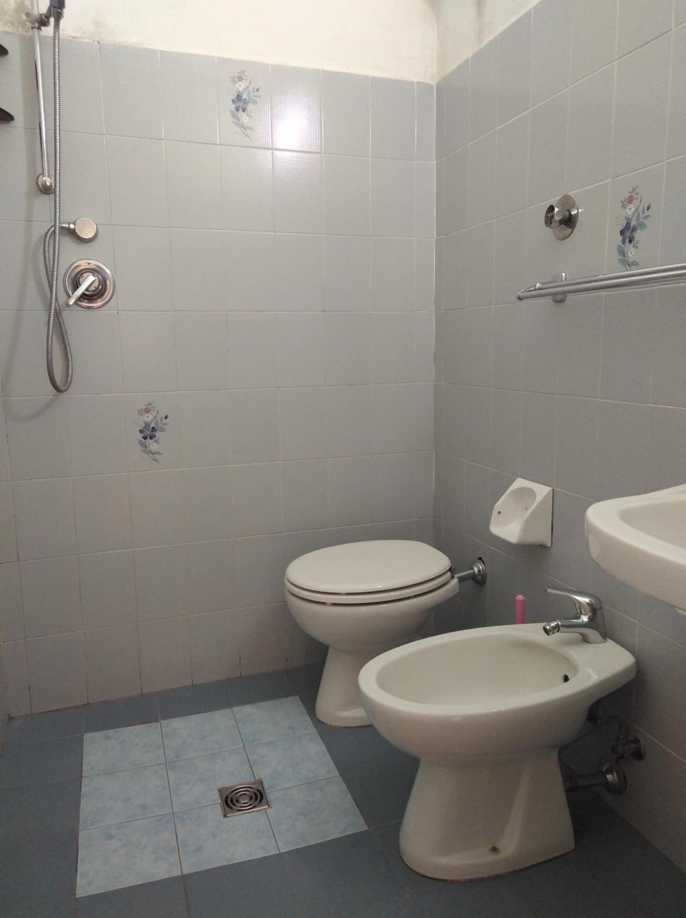 Un bagno con toilette, bidet e lavandino, tutto in bianco.