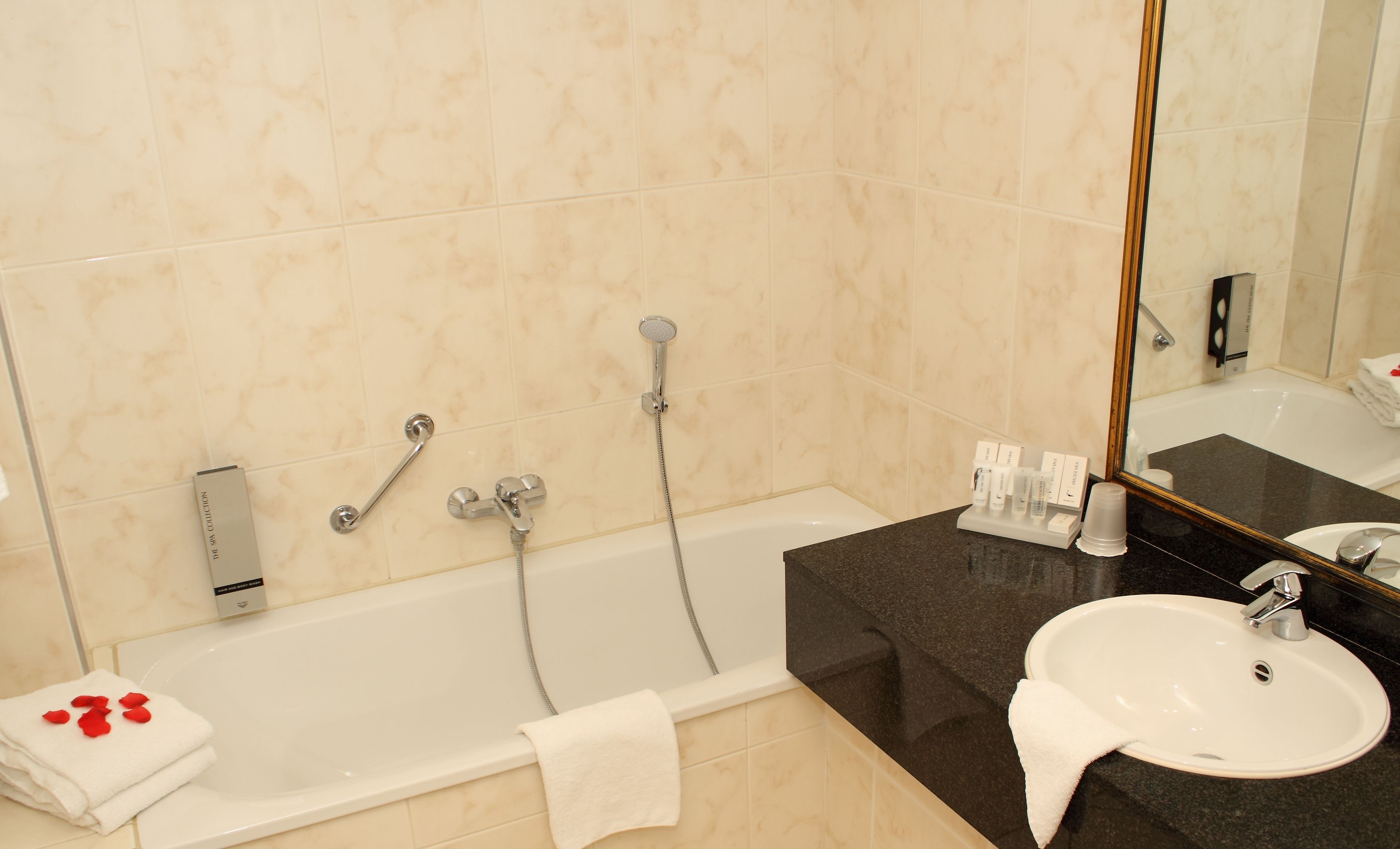 A bathroom with a bathtub, a sink, and a mirror.