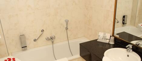 A bathroom with a bathtub, a sink, and a mirror.