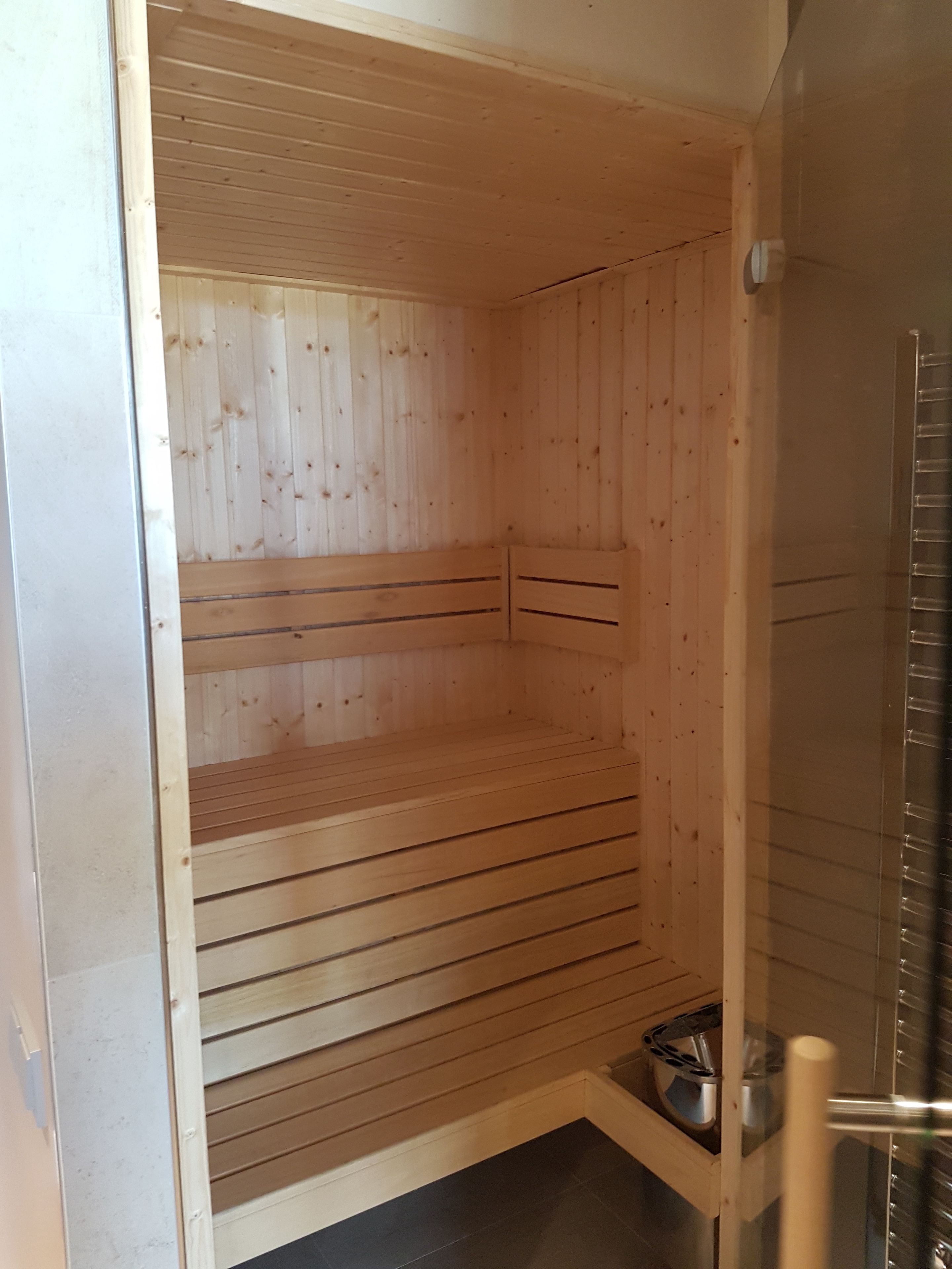 Un sauna avec des murs en bois et un sol carrelé.
