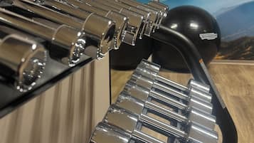 A metallic, reflective surface with a series of cylindrical objects and a curved black object.
