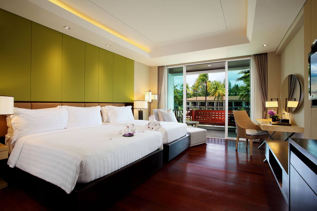 A modern hotel room with a large bed, a desk, and a chair.