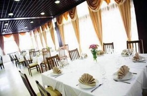 A dining area with tables set for a meal, featuring white tablecloths and folded napkins. - Pela Hotel Ohrid (Ohrid)