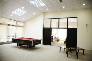 A room with a pool table, a glass table, and a view through a doorway. - Pela Hotel Ohrid (Ohrid)