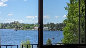 A view from a window overlooking a lake with boats, houses, and trees. - Western Riviera Lakeside Lodging (Grand Lake)