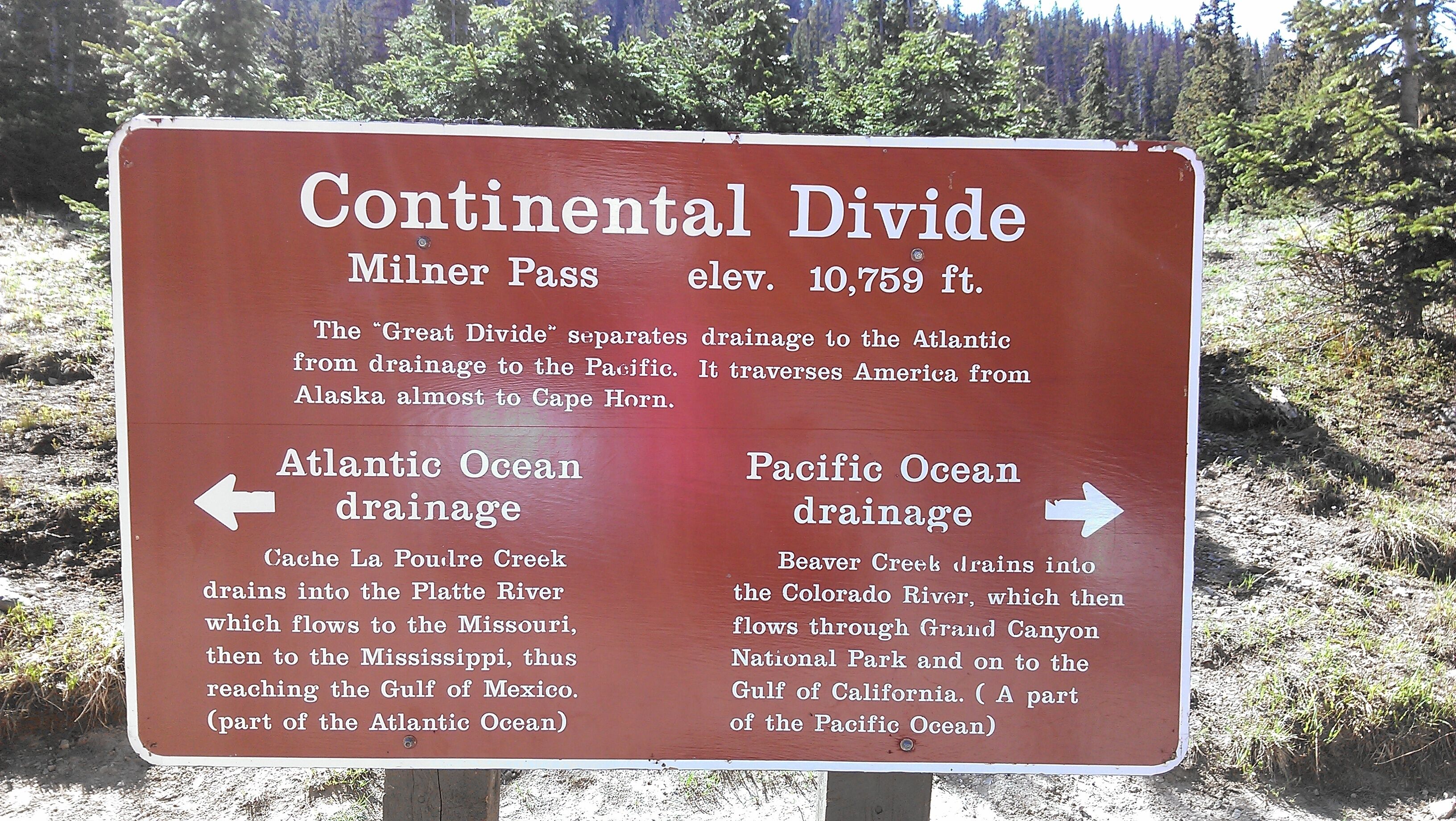 Un cartel sobre el Cordón Continental, que indica la altitud en Milner Pass y explica las cuencas de drenaje hacia el Océano Atlántico y el Pacífico.