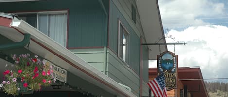 A Western Riviera building with a "Welcome" sign, a "Stay Caution" sign, and an American flag.