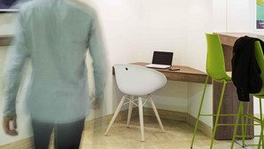 Een moderne kantoorruimte met een bureau, een laptop en twee stoelen.