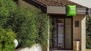 L’entrée d’un hôtel, avec une enseigne verte indiquant « ibis Styles Hotels ».