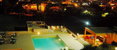 Alberca al aire libre y camastros