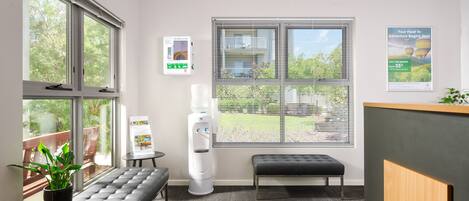 A reception area with a bench, a water dispenser, a defragmentation station, and a poster advertising a hot air balloon ride.