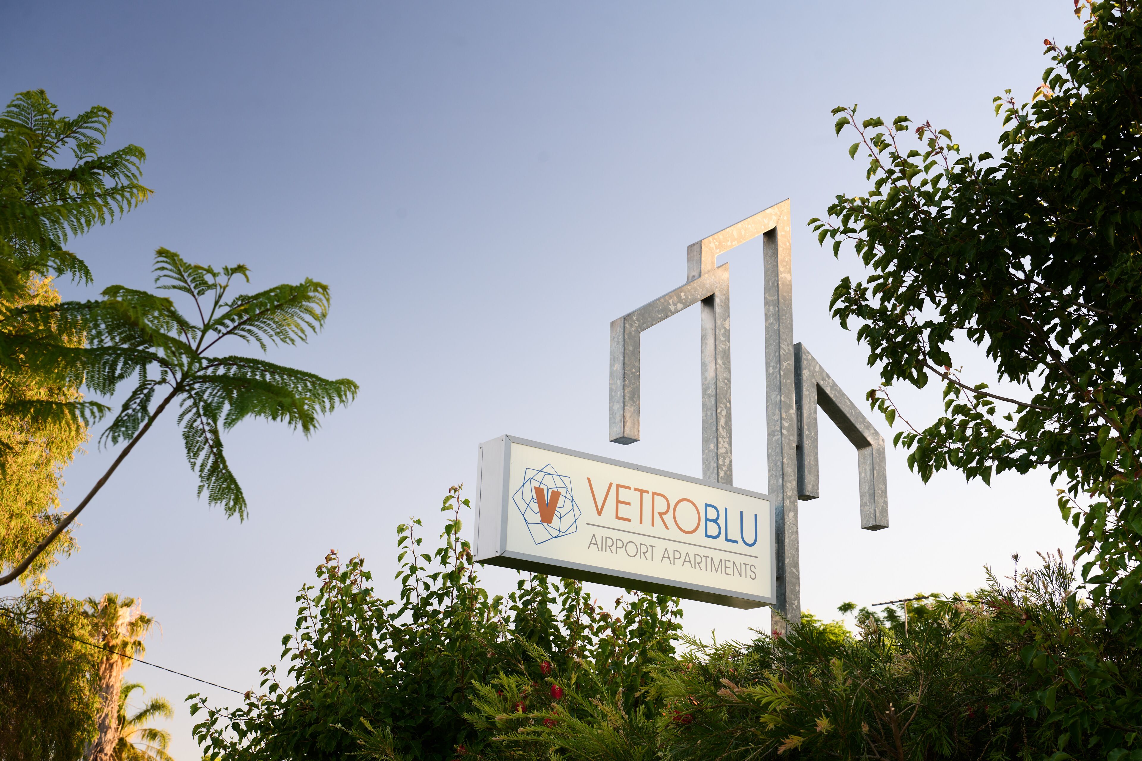Señal para VetroBlu Airport Apartments, con un diseño moderno y un logotipo.
