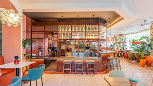 Uma área de bar com balcão, banquetes e prateleiras repletas de garrafas.