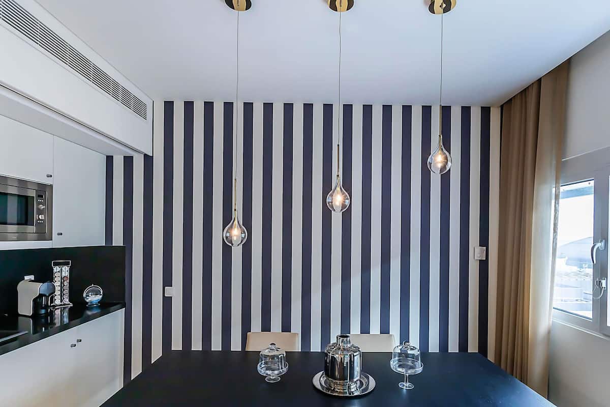A modern kitchen with a microwave, a coffee machine, and a black countertop.