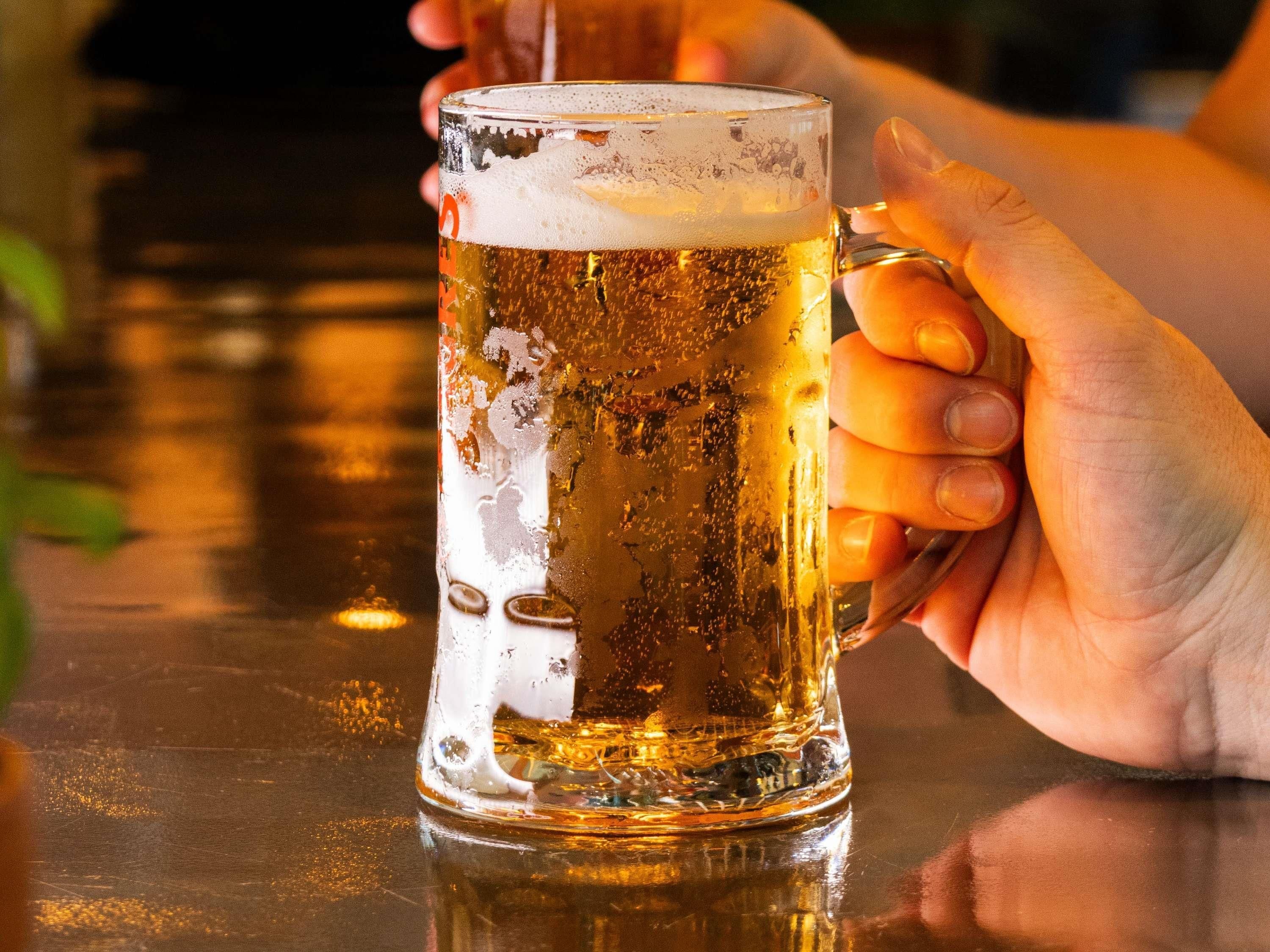 A hand holding a beer mug.