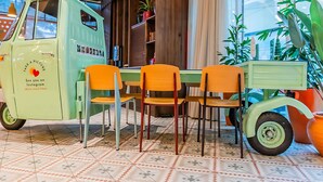 Un vecchio camioncino verde con un tavolo e sedie in una stanza con piastrelle decorate e piante in vaso.