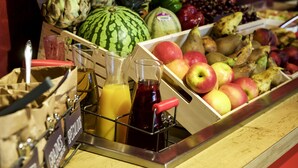 Een presentatie van fruit met verschillende soorten en een sapdispenser.