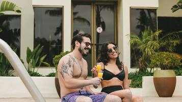 A couple sitting by a pool with a sign reading "Marina SPA" above.
