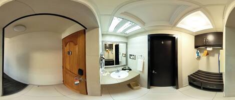 A modern bathroom with a wooden door, a black door, a sink, and a mirror.