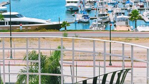 A balcony with a metal table and chairs overlooking a marina with numerous boats. - Corona Hotel & Spa (Ensenada)