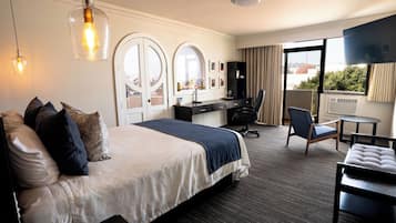 Ein Hotelzimmer mit Bett, Schreibtisch, Stuhl und Fernseher.