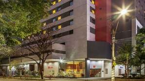 A multi-story hotel with a modern facade, multiple windows, and a visible entrance with signage. - ibis BH Afonso Pena Savassi (Belo Horizonte)