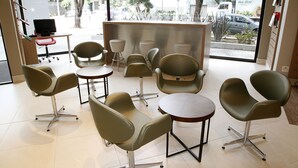 A modern interior with multiple seating areas, a reception desk, and a view of the street outside. - ibis BH Afonso Pena Savassi (Belo Horizonte)