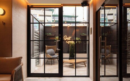A modern interior with a glass door leading to an outdoor seating area.