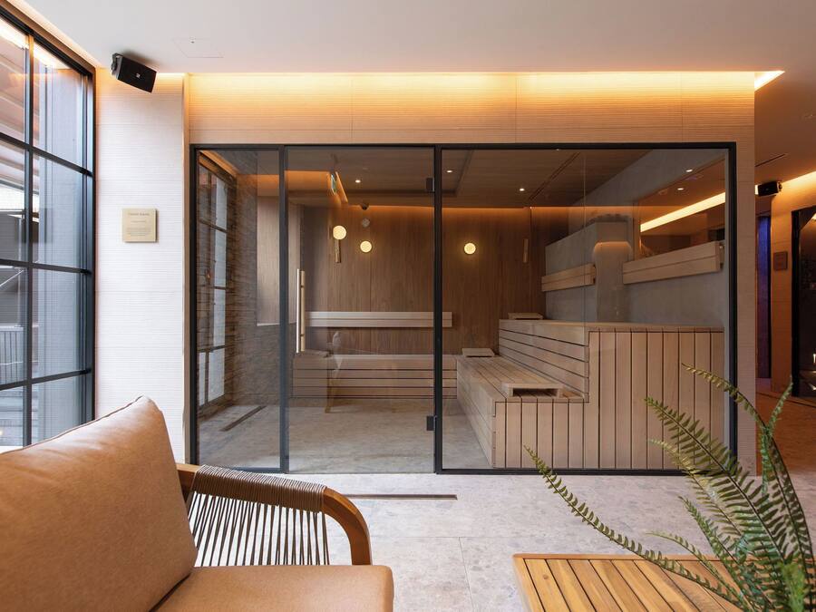 A modern interior with a glass partition, wooden seating, and a reception area.