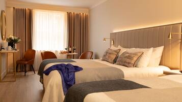 A hotel room with two beds, a desk, and a chair.