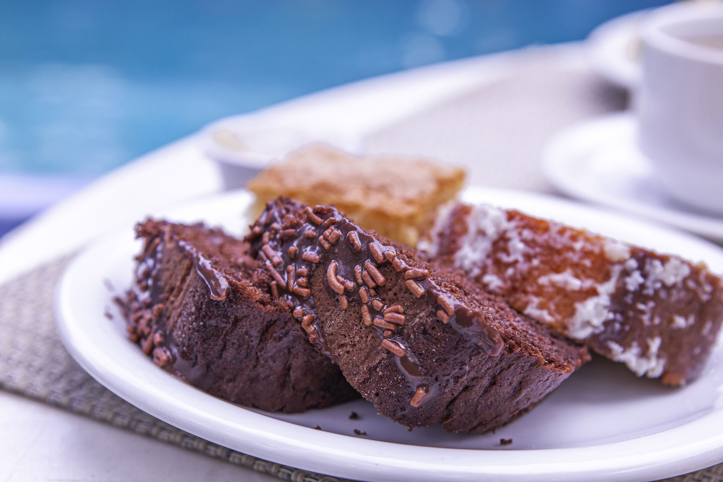 Une assiette remplie de desserts au chocolat et une tasse de café sur une table.