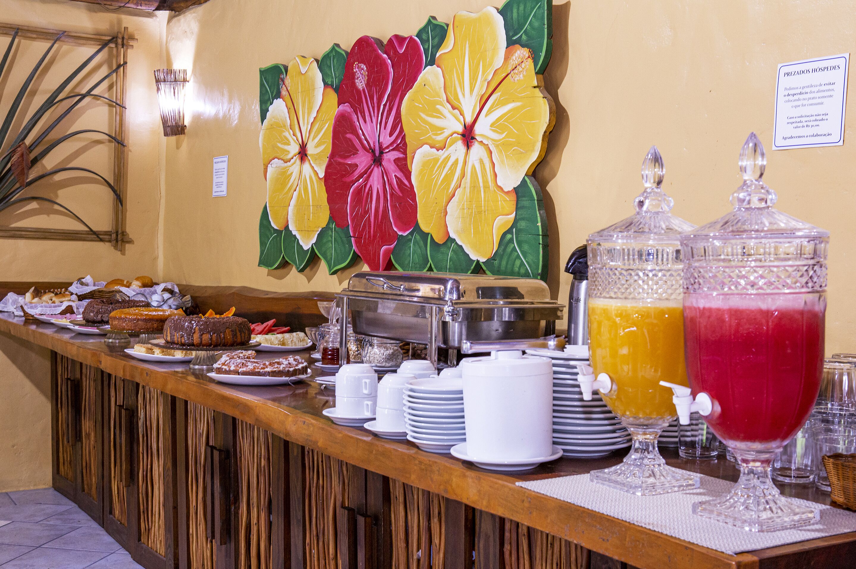A buffet setup with various food items, a fruit wall, and a juice dispenser.