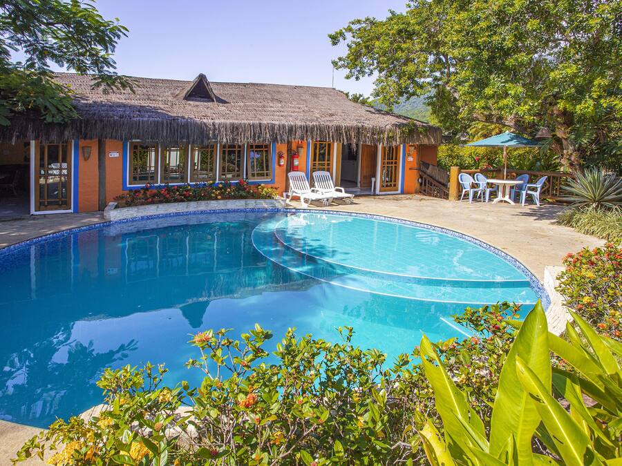 Een buitenzwembad, ligstoelen bij het zwembad