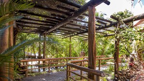 Un puente de madera sobre una masa de agua, con una pérgola de madera encima.