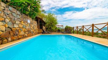 Een buitenzwembad, parasols voor strand/zwembad