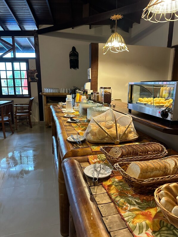 Montaje de un bufé de desayuno con diferentes alimentos y una máquina de café.