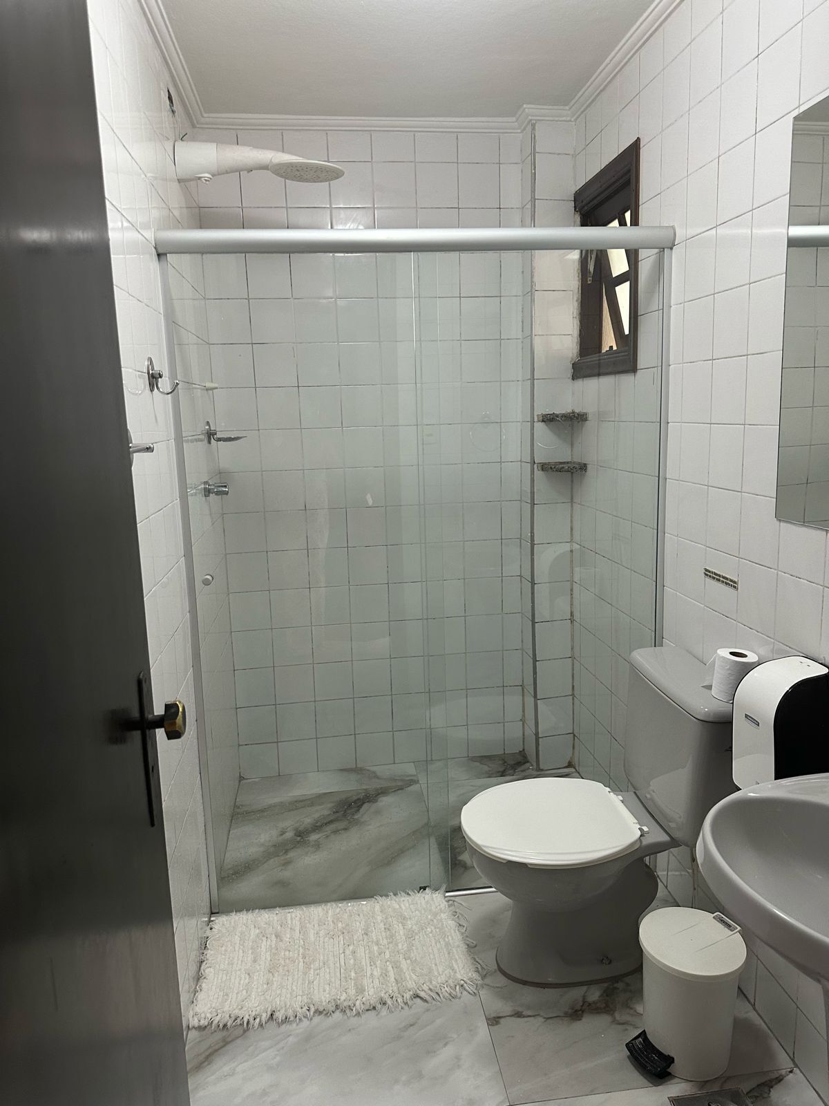 Un baño con ducha de vidrio, inodoro, bidé y lavamanos.