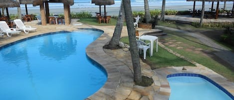 Een buitenzwembad, parasols voor strand/zwembad