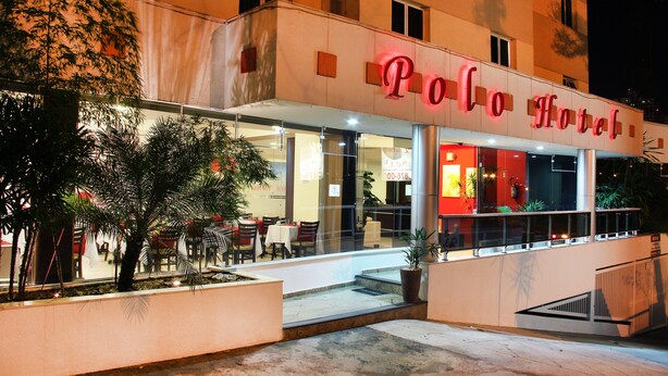 A hotel with a glass facade, outdoor seating, and a sign reading "Polo Hotel". - Polo Hotel (São José dos Campos)