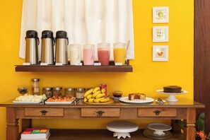 A breakfast buffet with various food items and beverages. - Pousada Villaggio Assis (Ilhabela)