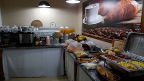 Un montaje tipo buffet con diversas opciones de comida y una estación de café.
