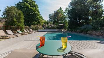 Alberca al aire libre y camastros