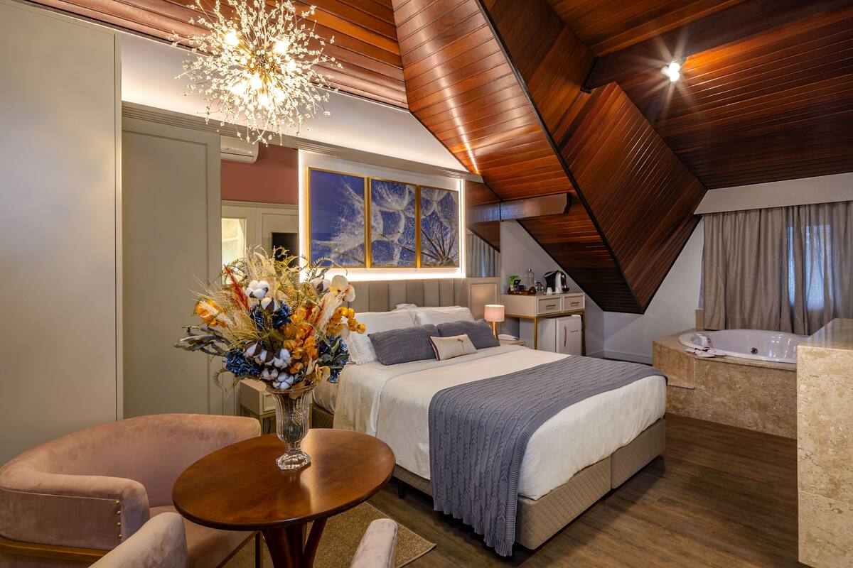Ein modernes Schlafzimmer mit einem großen Bett, einer Sitzecke, einem Schminktisch und einer Badewanne.