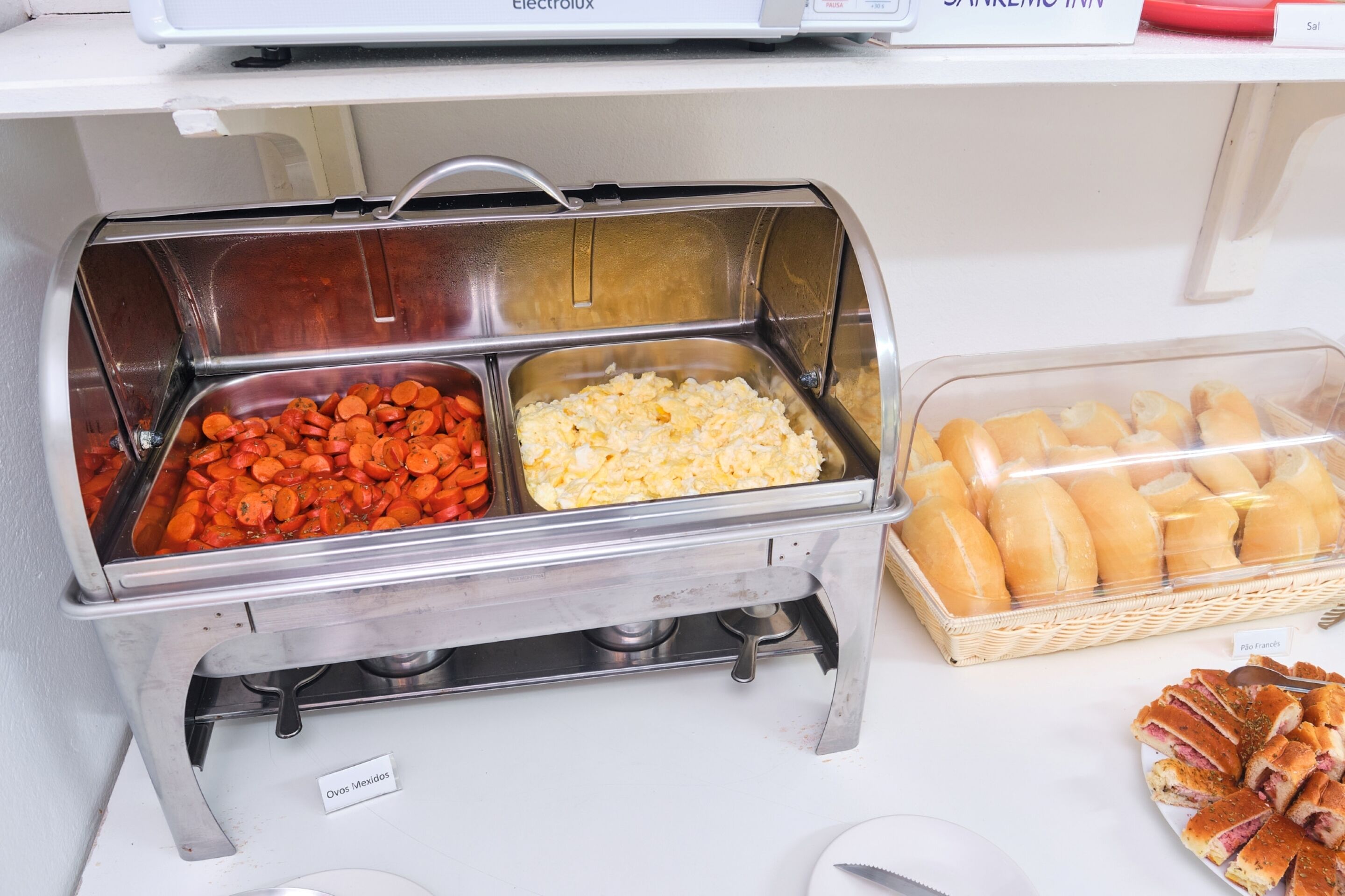 A buffet with labeled sections for different food items, including a section for 'Ovos Mexidos'.