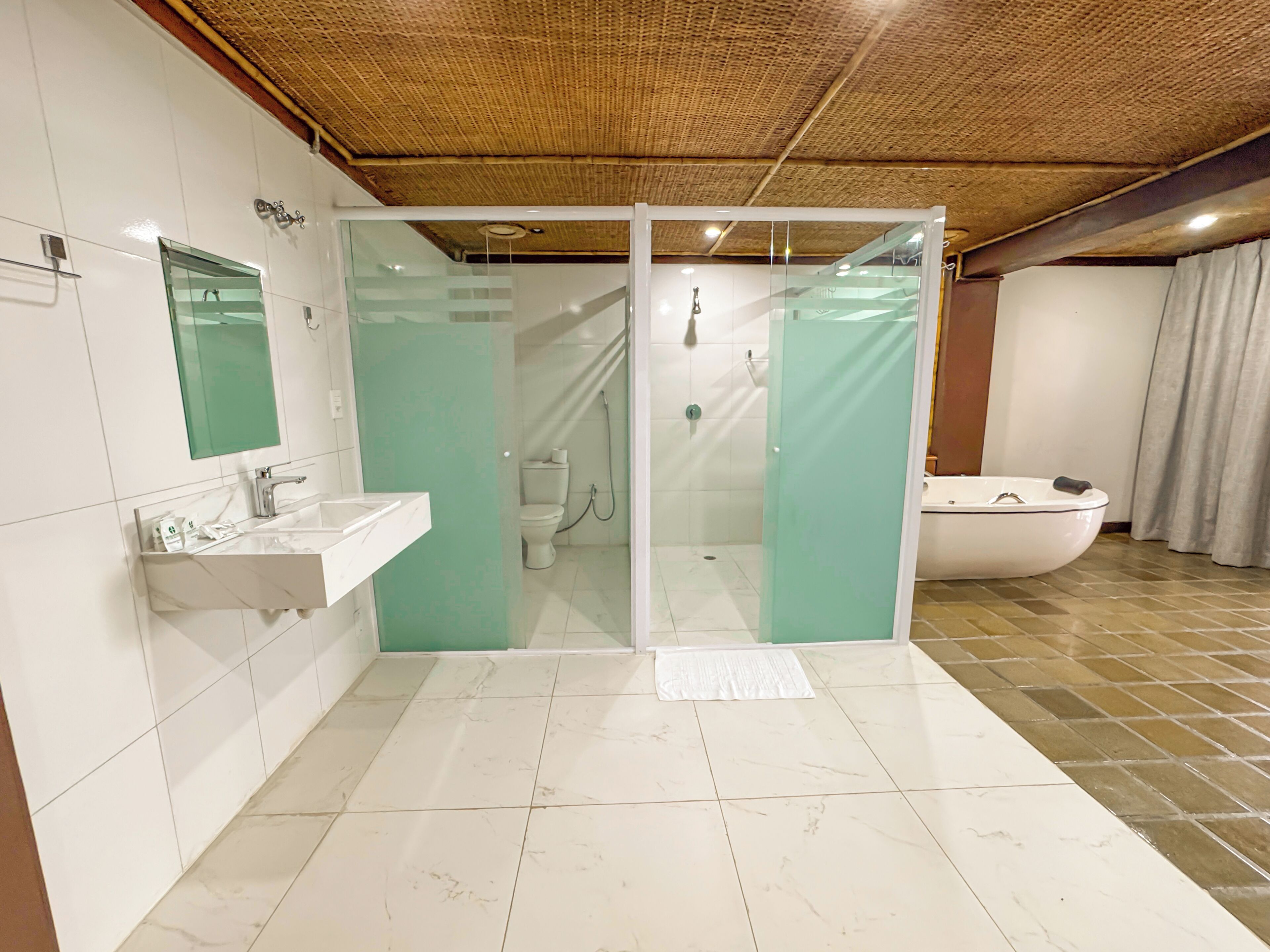 Un baño moderno con ducha acristalada, lavamanos blanco y bañera.