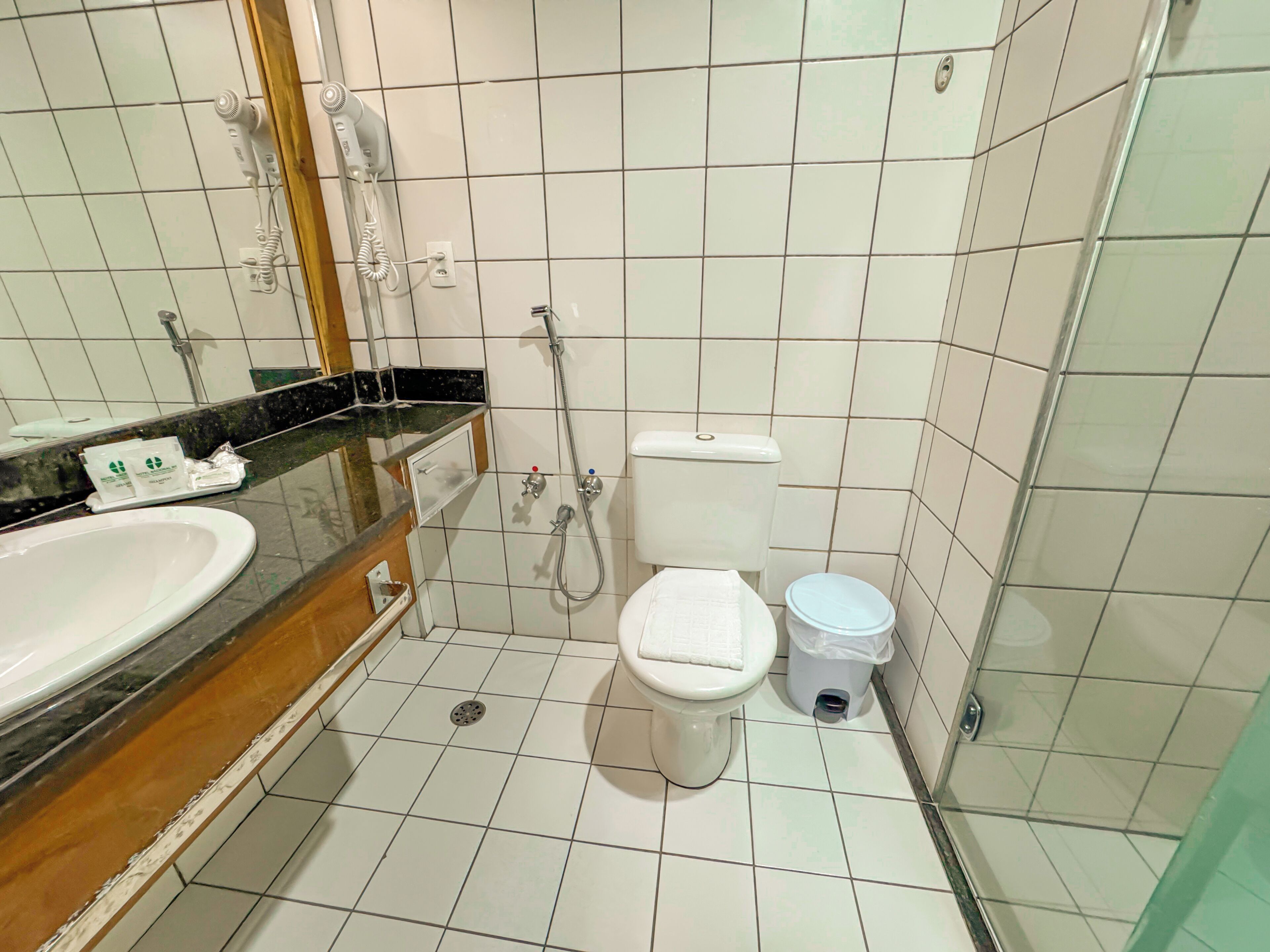 A bathroom with a white sink, a toilet, and a shower.