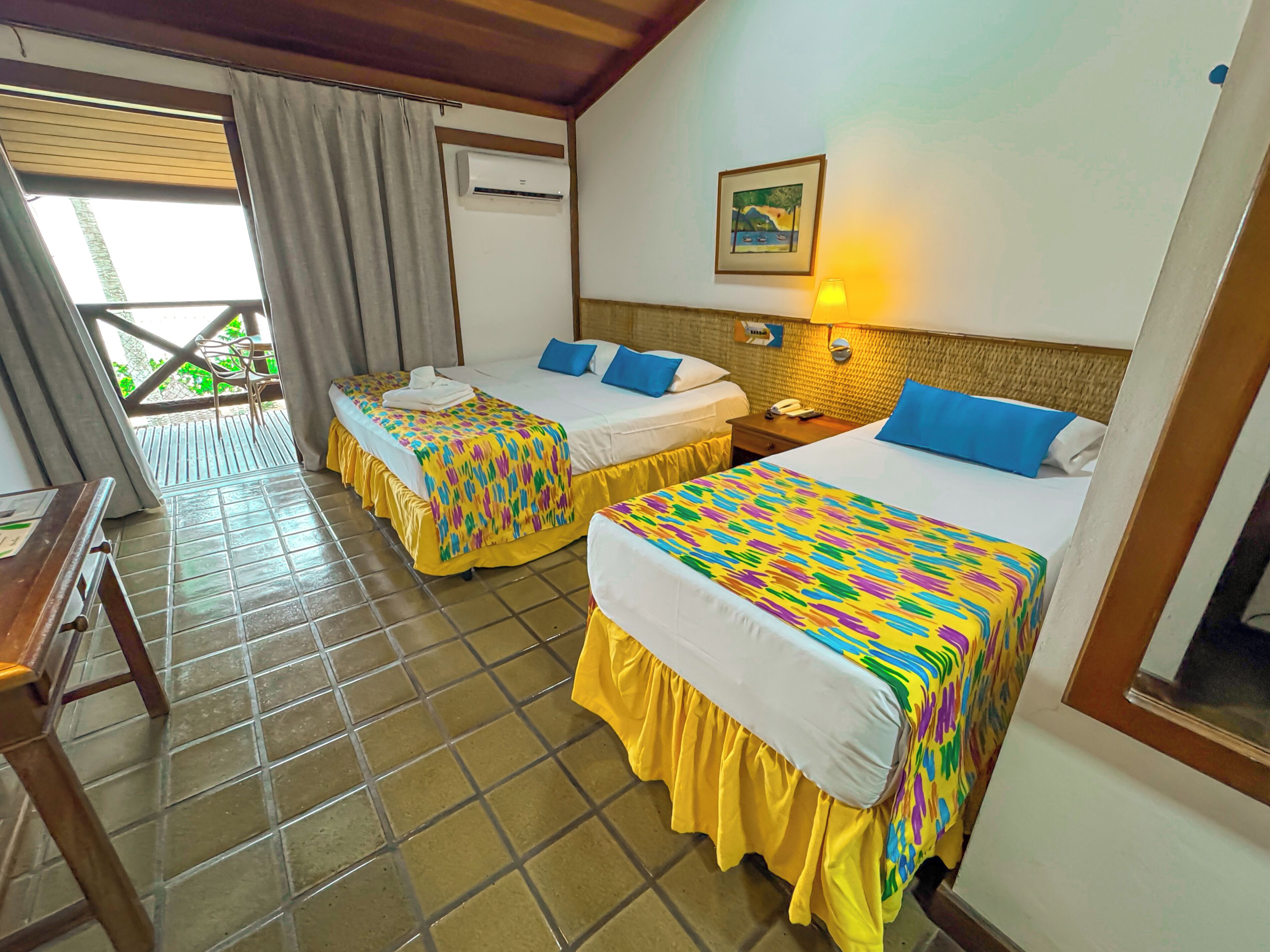 A hotel room with two beds, a telephone, and a window with curtains.